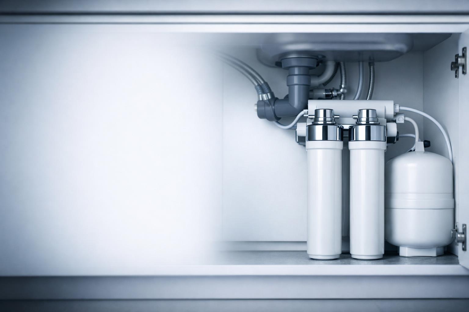 Under-sink water filtration system installed inside a kitchen cabinet